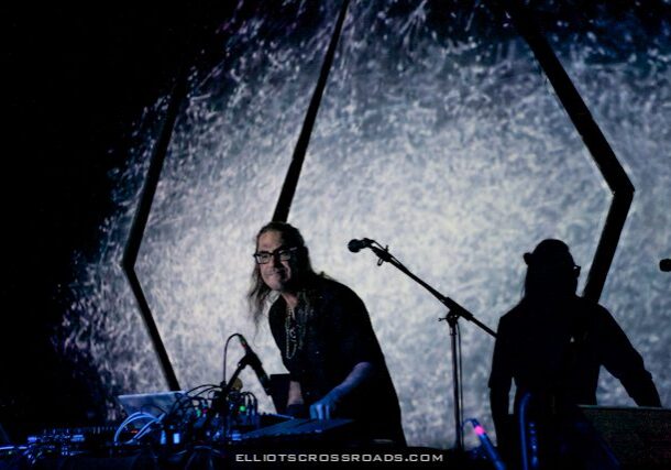 Musician performing with electronic equipment on stage.