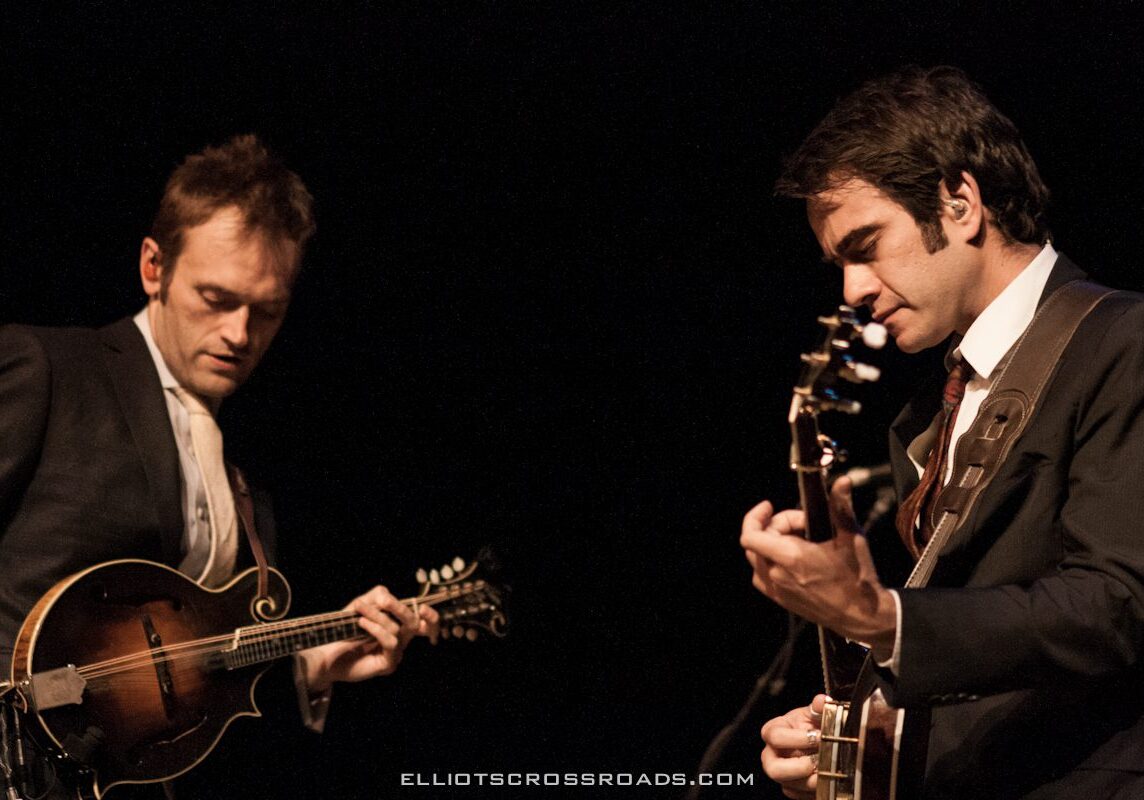 Two musicians playing string instruments on stage.