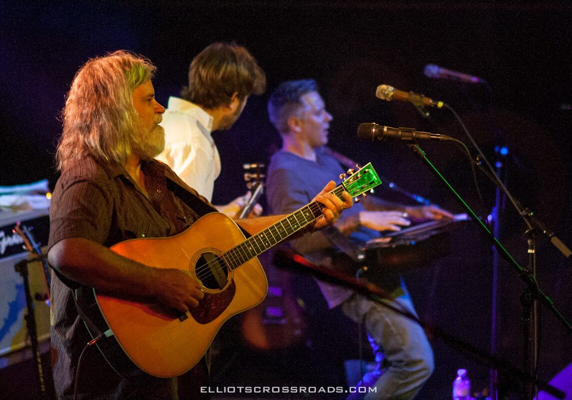 Musicians performing on stage with instruments.