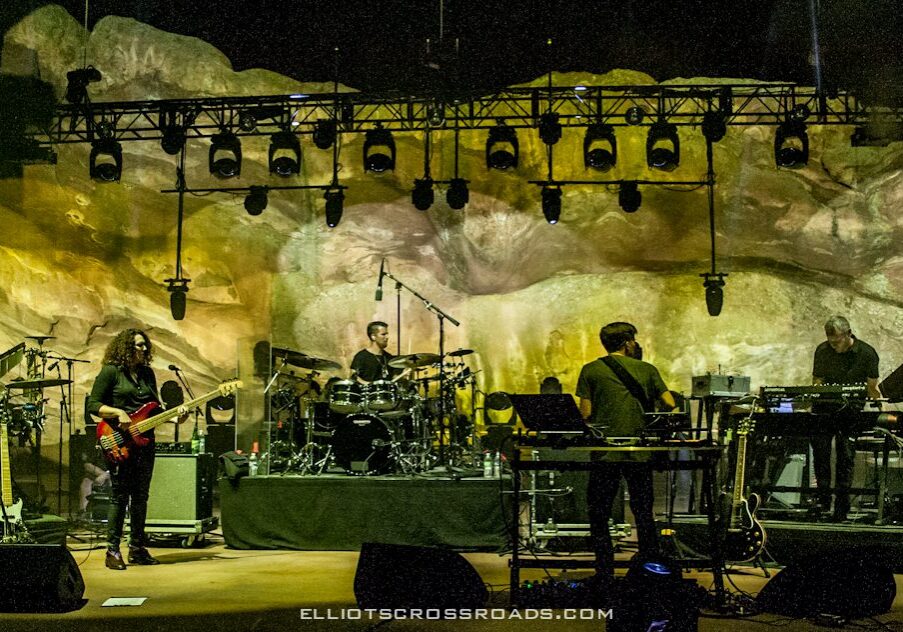 Band performing on stage with colorful lighting.