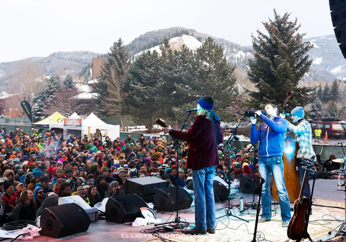 Outdoor concert with band performing to crowd.