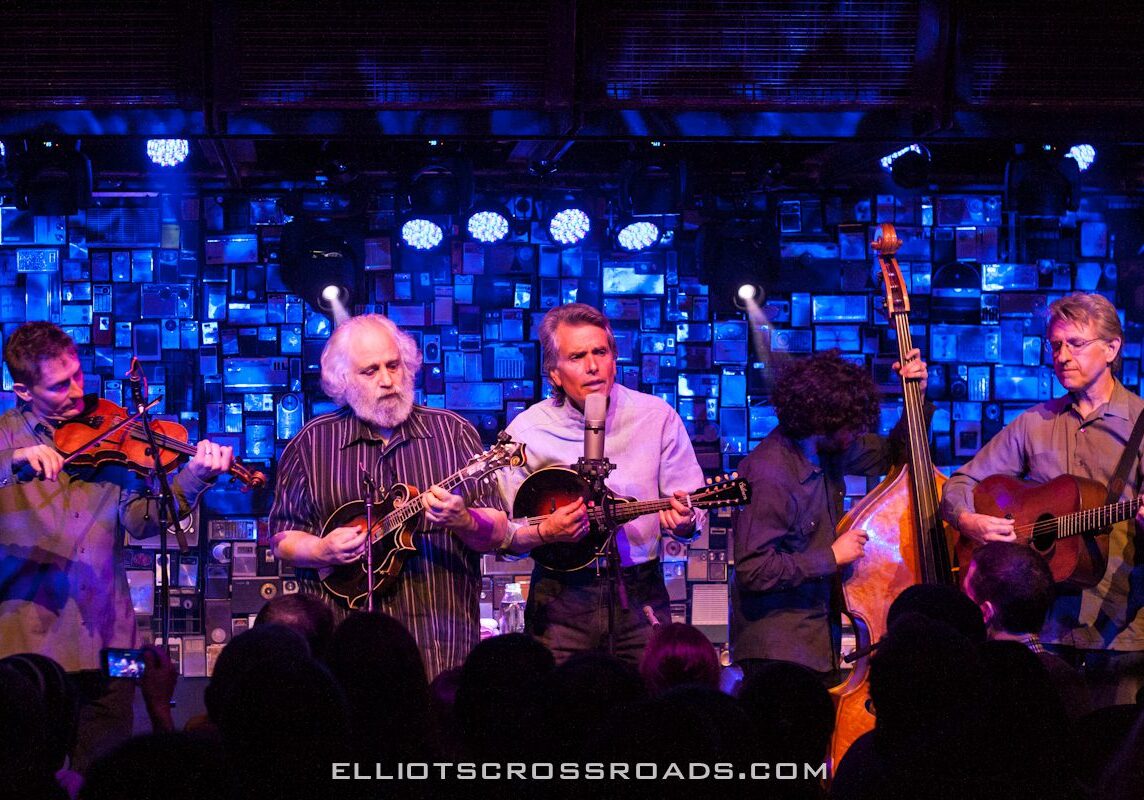 Band performing on stage with blue lighting.