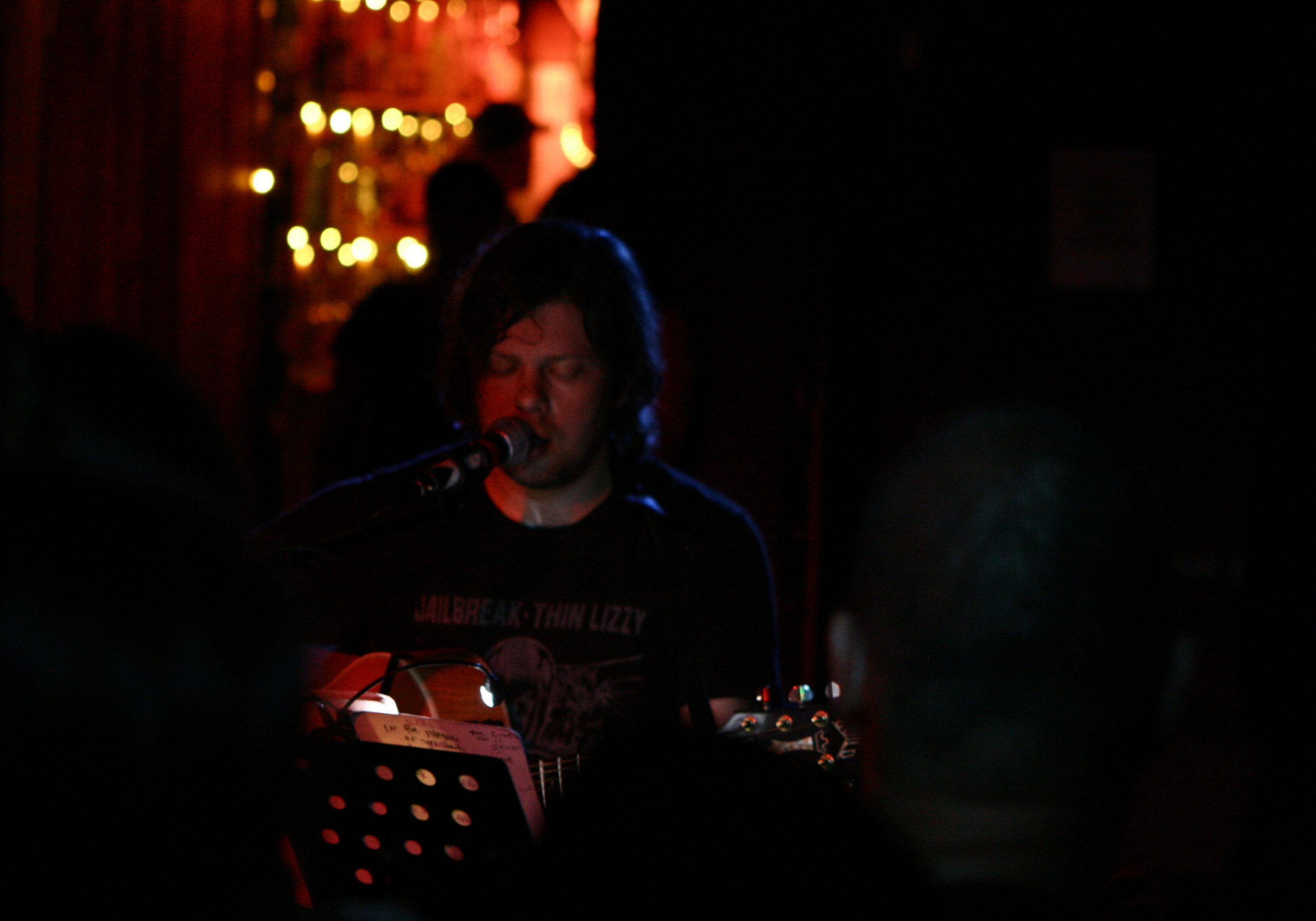 Musician performing on stage with guitar.