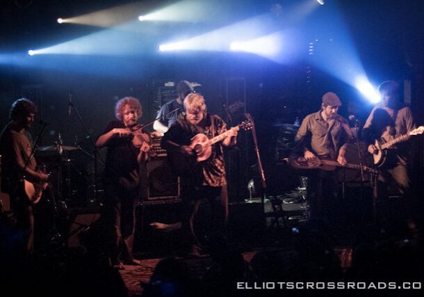 Band performing on stage with instruments.