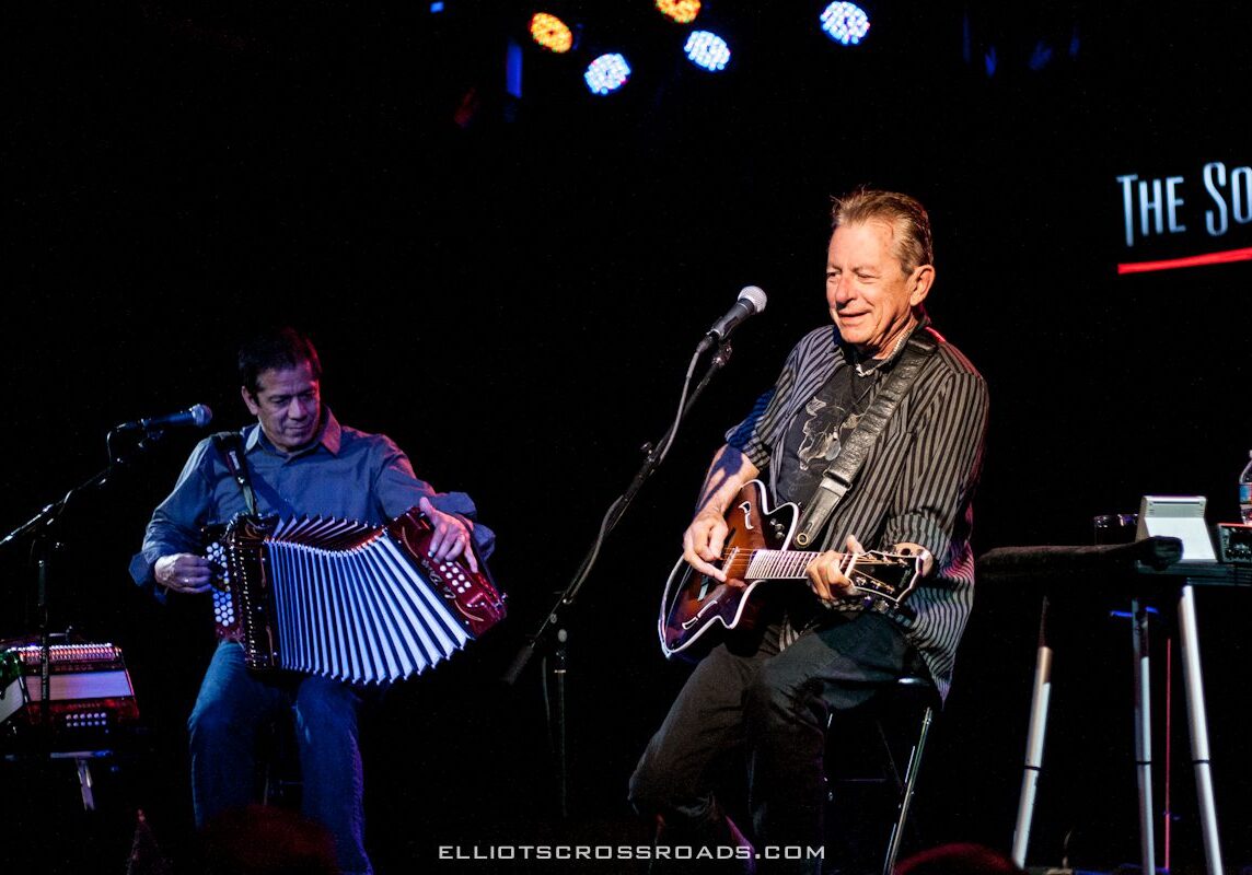 Musicians performing on stage with instruments.