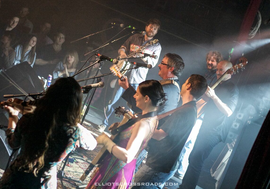Band performing live on stage with audience.