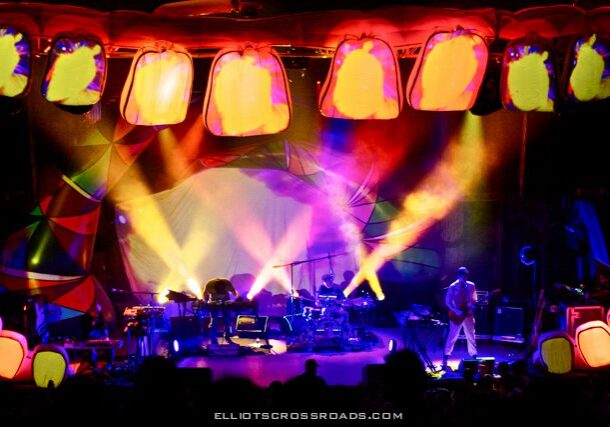 Colorful stage with vibrant lights and performers.