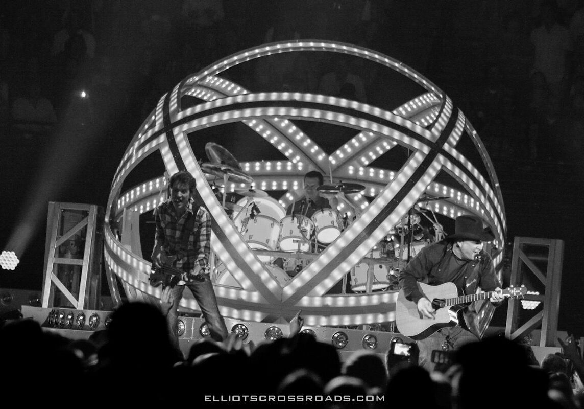 Band performing on stage with illuminated structure.