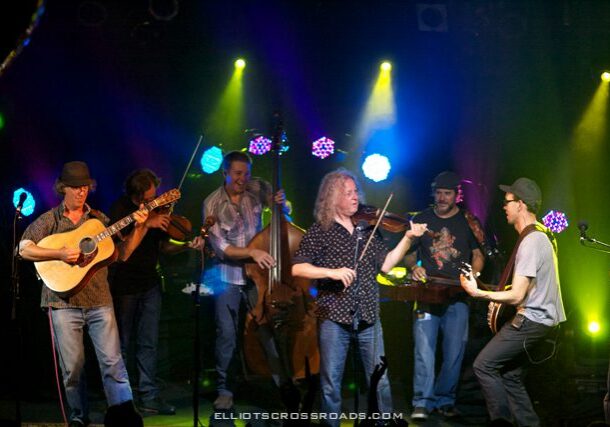 Band performing on stage with colorful lights.