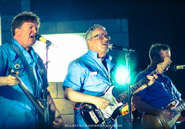 Band performing on stage with instruments.