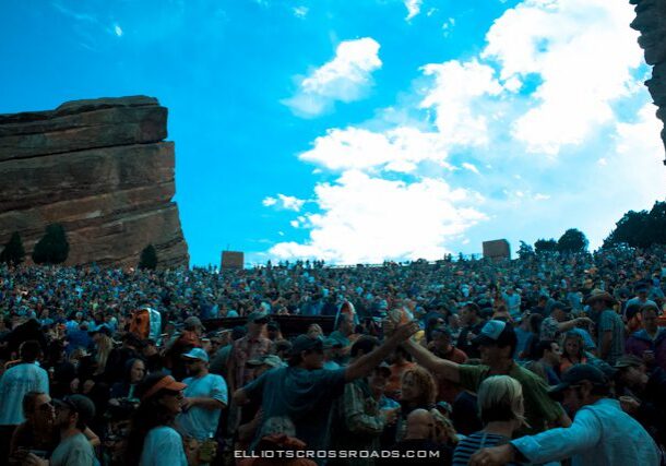 Crowd at outdoor amphitheater under blue sky.