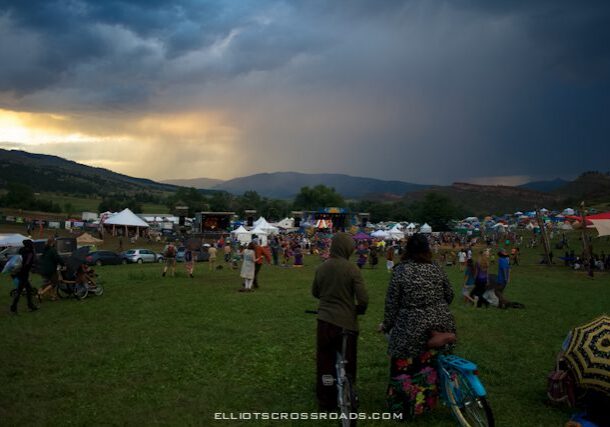 Outdoor festival with tents and gathering crowd.