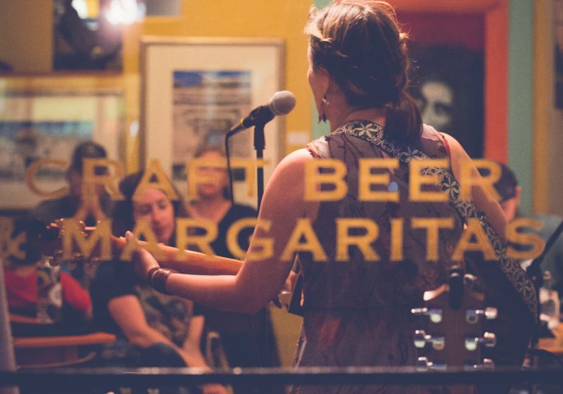 Singer performing in a cozy, colorful venue.