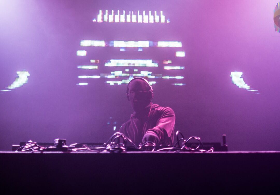DJ performing on stage with lights.