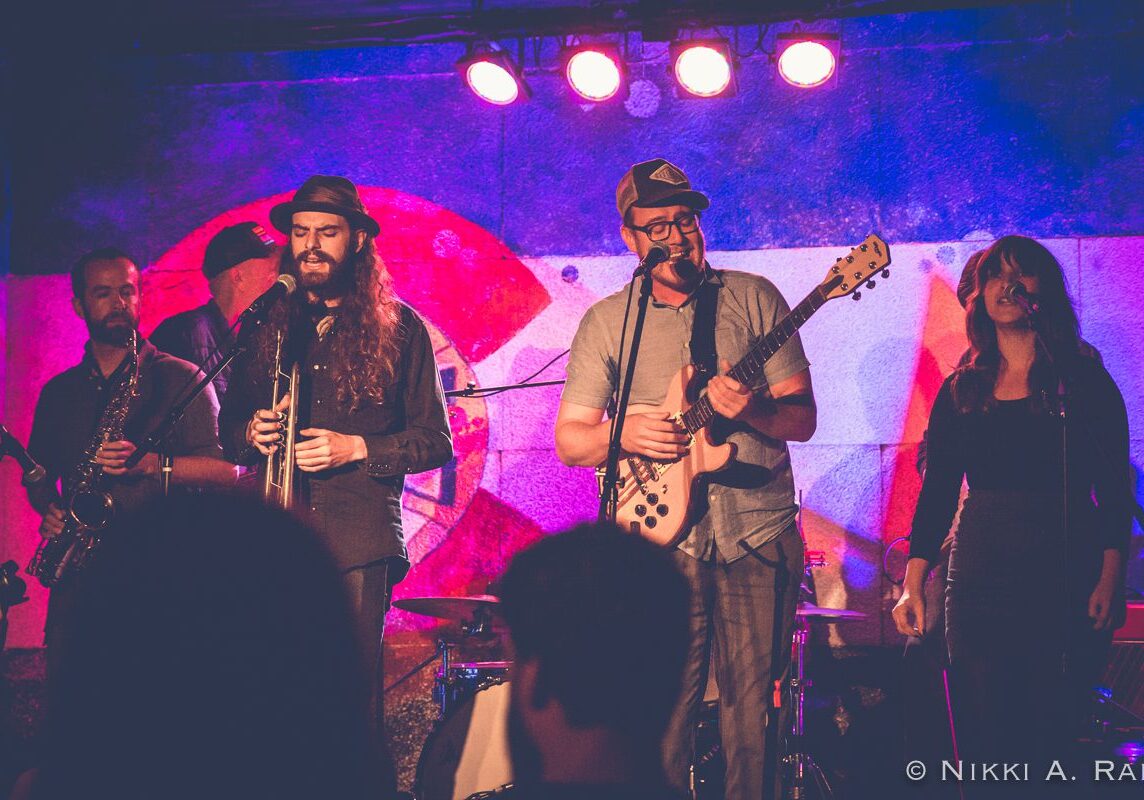 Band performing on stage with instruments.