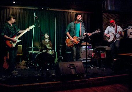 Band performing on stage with instruments.