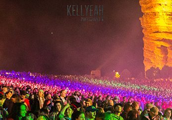 Concert crowd at Red Rocks Amphitheatre, illuminated.