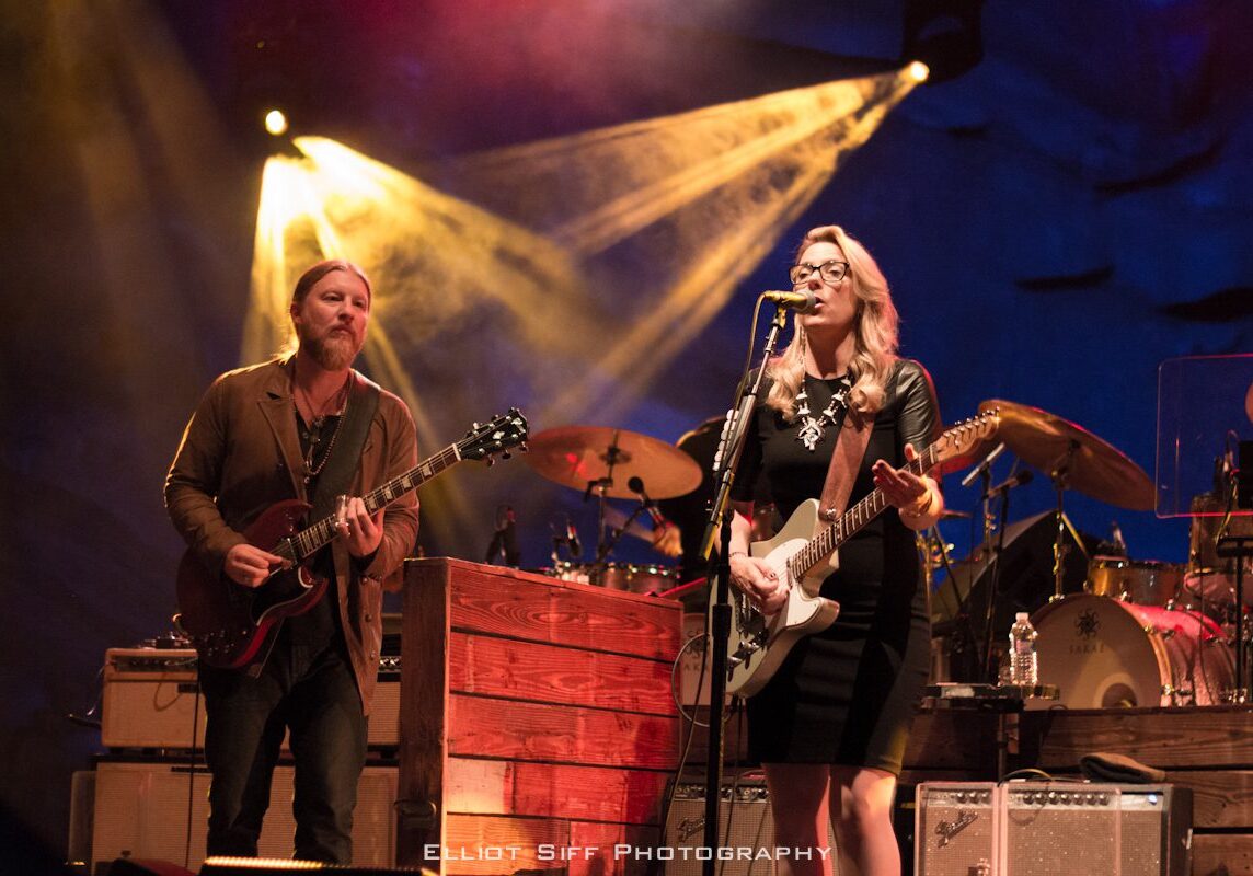 Musicians performing live on stage with guitars.