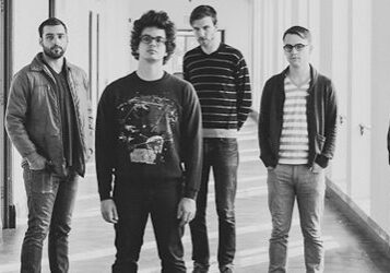 Six men standing in a hallway together.