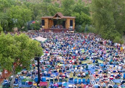 Outdoor concert with large seated audience.