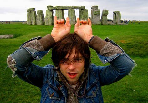 Person posing playfully in front of Stonehenge.
