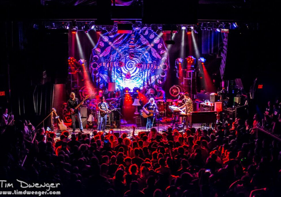 Live band performing on stage with audience.