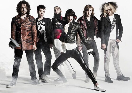 Band posing with stylish, eclectic fashion choices.