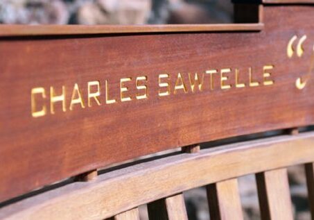 Wooden bench with "Charles Sawtelle" engraved text.