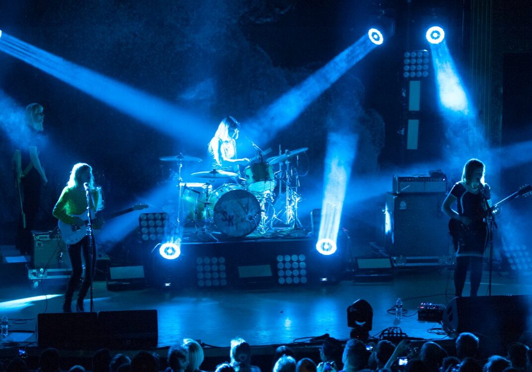 Band performing on stage with blue lights.