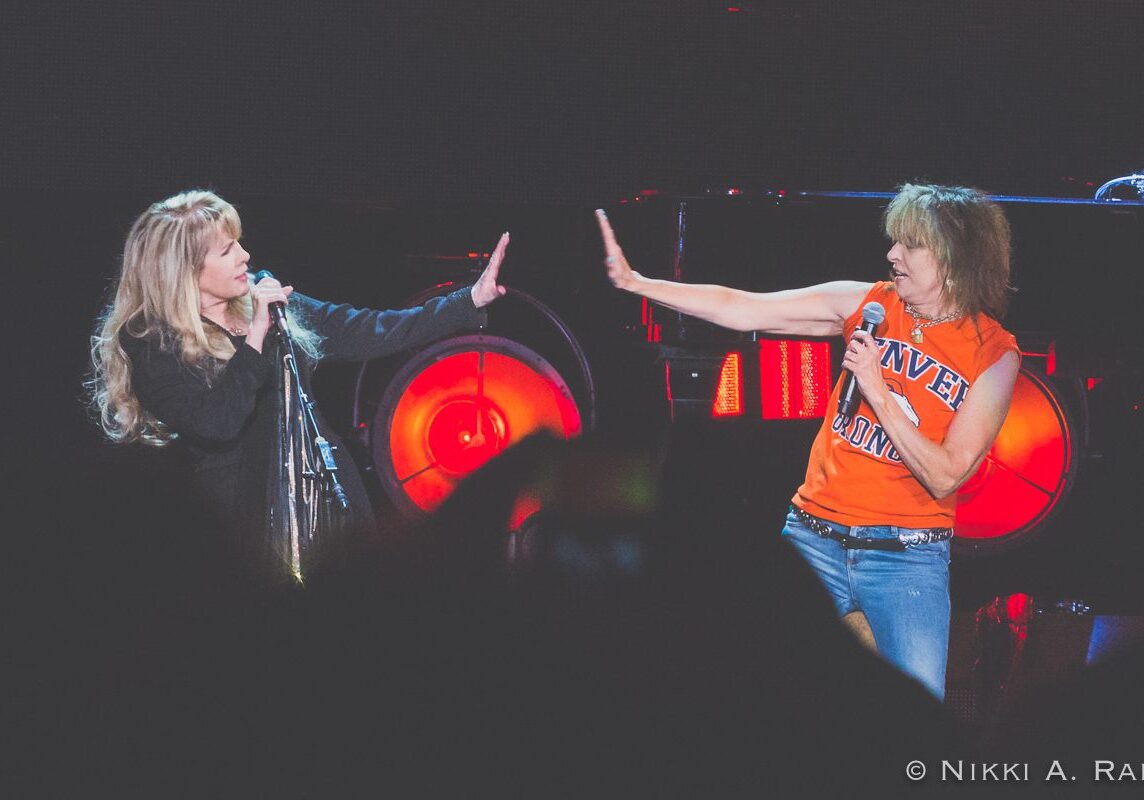 Two performers singing and gesturing on stage.