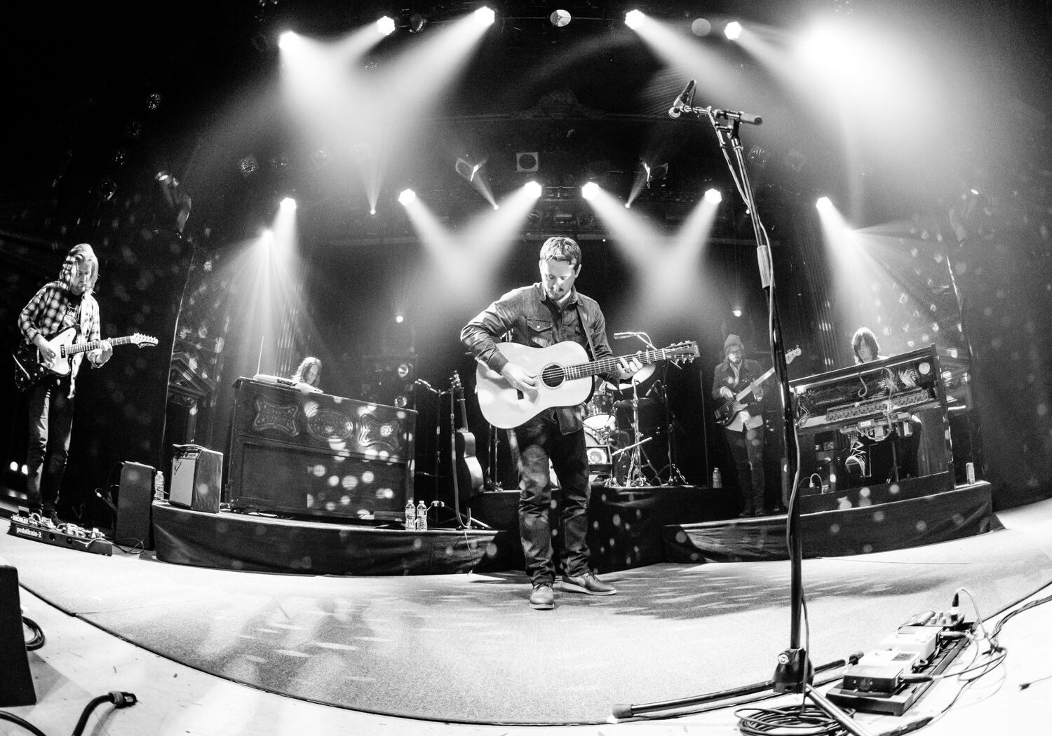 Band performing live on stage with guitars.