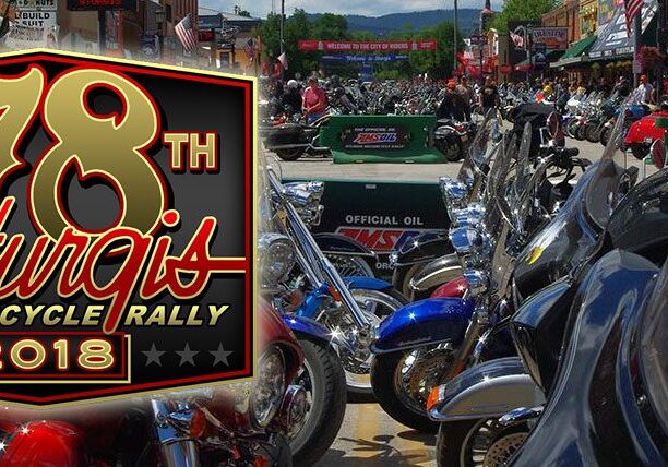 Motorcycle rally with parked bikes and banner.