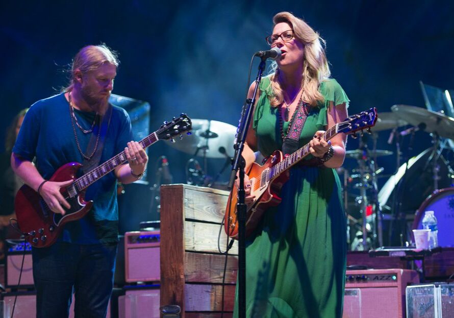 Musicians performing on stage with guitars.