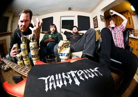 Band members relaxing with drinks and instruments.