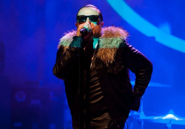 Singer performing on stage with fur jacket.