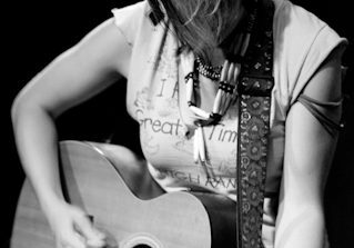 Musician playing acoustic guitar, black and white.