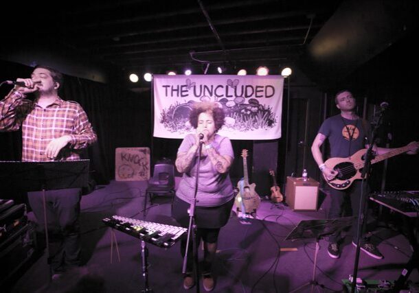 Band performing on stage with instruments.