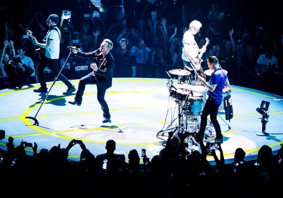 Band performing on a circular stage, live concert.