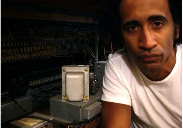 Man beside vintage electronic equipment.