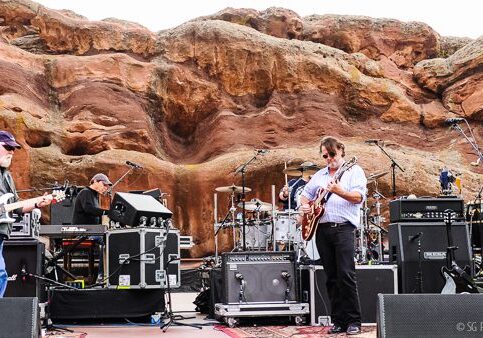 Band performing at outdoor rock amphitheater.