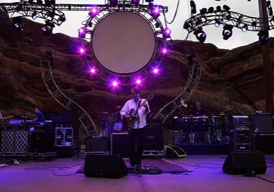 Band performing on stage with purple lights.