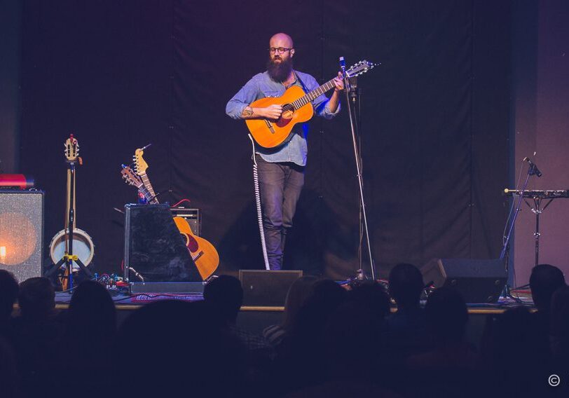 Band performing on stage with instruments.