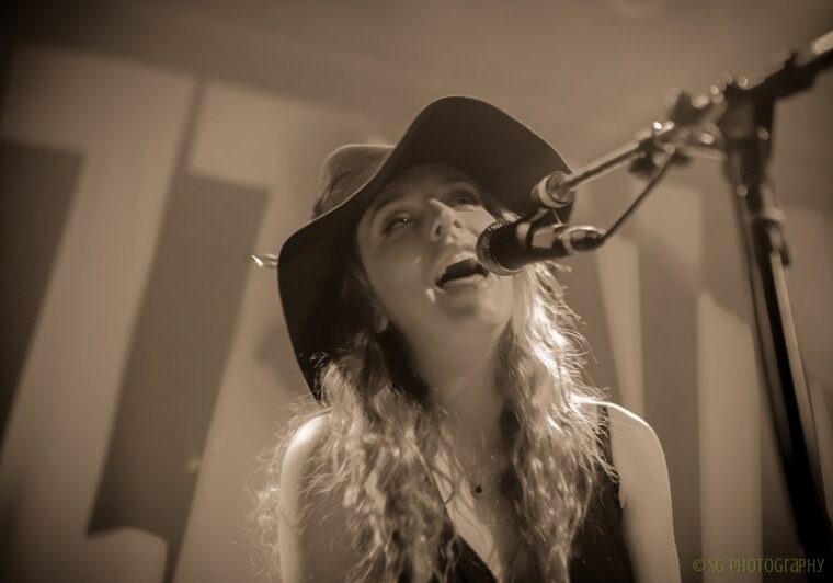 Singer performing on stage with microphone.