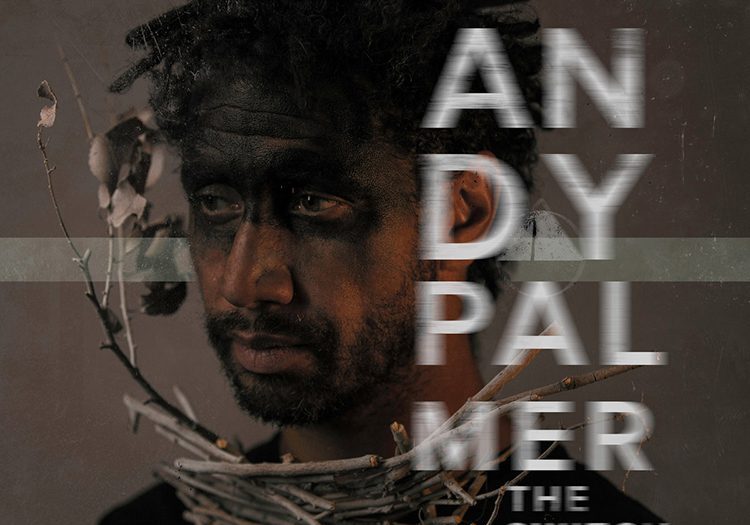 Man with branches and dark face paint.