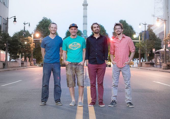 Four men standing on a city street.