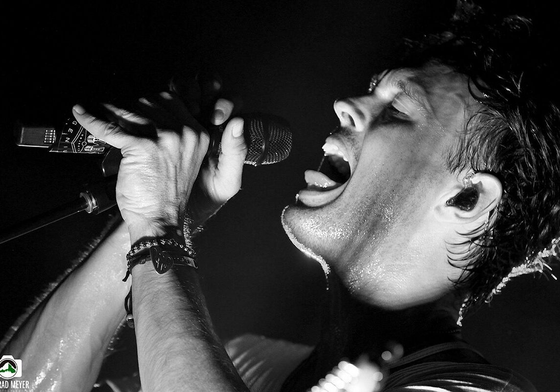 Singer performing passionately with a microphone.