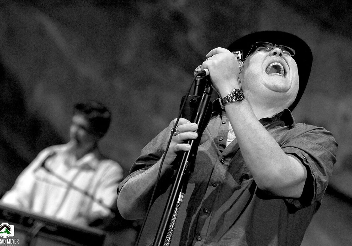Singer passionately performing on stage with microphone.