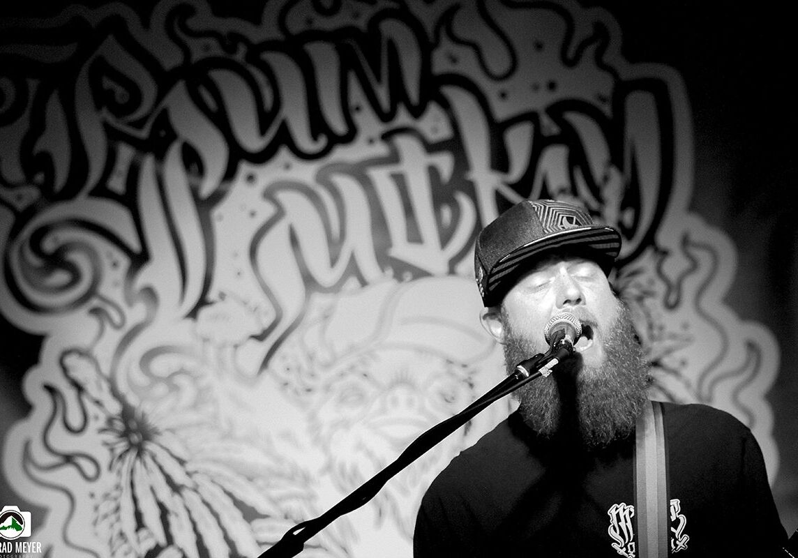 Singer performing with graffiti backdrop.