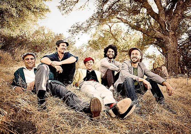 Group of people sitting outdoors, smiling.