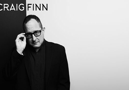 Man in black suit with glasses.